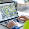 Person using laptop, viewing a map.